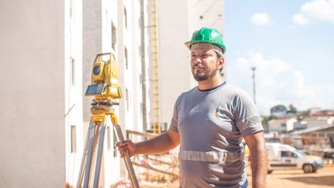 Engenheiro operando Estação Total de Precisão no campo